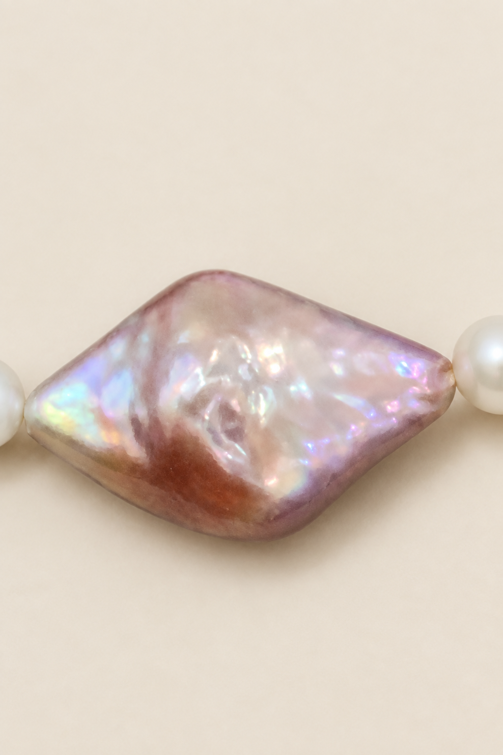 Close-up of purple-pink centre pearl on warm ivory background