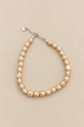 Baby Bubbles golden-peach pearl bracelet on warm beige background