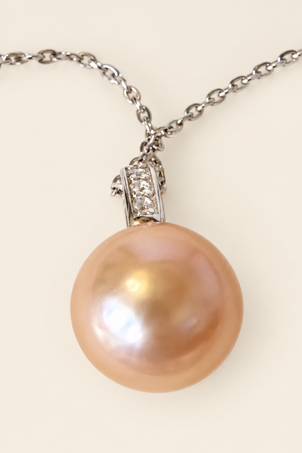 Close-up of golden peach pearl and sparkling bail