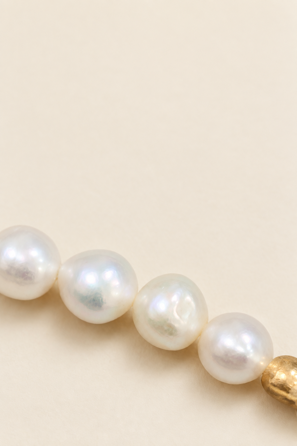 Close-up of brilliant white pearls on warm ivory background